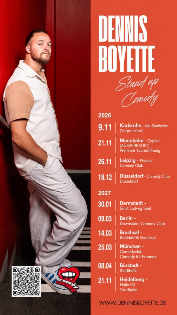 Man in a white shirt and pants leans against a red wall next to an orange Dennis Boyette stand-up tour poster with 2026 dates and venues (Karlsruhe, Mannheim, Leipzig, etc.).